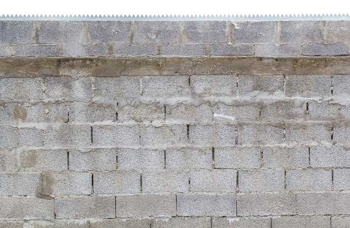 Fases de colocação de uma cerca em blocos de betão pela Avenir Obras